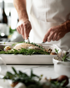 Spreading herb butter under turkey skin before roasting for a juicy, golden finish